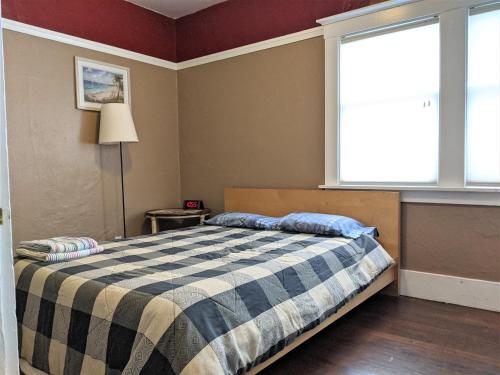 1 dormitorio con cama y ventana grande en Relax in unpretentious peaceful and authentic house with public transportation cafes and U of Berkeley close by, en Albany