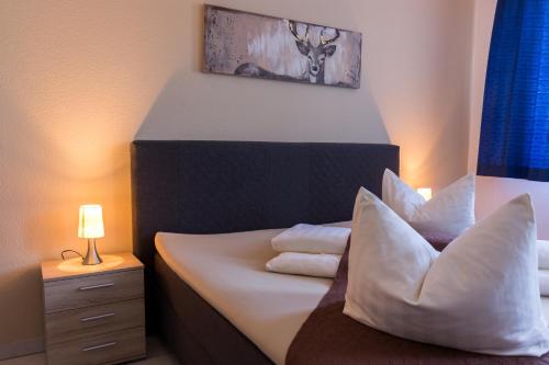 a bedroom with a bed with white sheets and pillows at Gasthaus zur Grässelmühle in Sasbach in der Ortenau