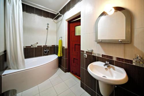 a bathroom with a sink and a red door at Едем in Skhidnitsa