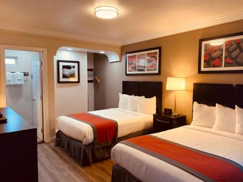 um quarto de hotel com duas camas e duas lâmpadas em The Lexmar - Dodger Stadium Hollywood em Los Angeles