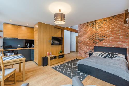ein Schlafzimmer mit einer Ziegelwand, einem Bett und einem Tisch in der Unterkunft Loft Apartments in Danzig