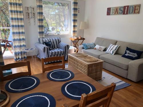uma sala de estar com uma mesa e cadeiras e um sofá em Apartament Visby em Jurata