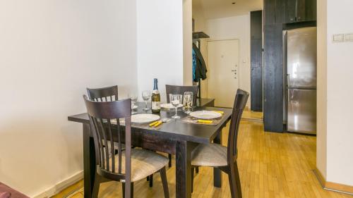 comedor con mesa con sillas y nevera en Apartment Central Square, en Belgrado