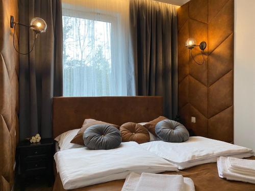 una camera da letto con un letto con cuscini di Family & Business Sauna Apartments No 7 Leśny nad Zalewem Cedzyna Unikat - 3 Bedroom with Private Sauna, Bath with Hydromassage, Terrace, Garage, Catering Options a Kielce
