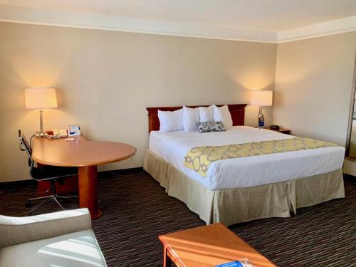 a hotel room with a bed and a table at Baymont by Wyndham Texarkana in Texarkana