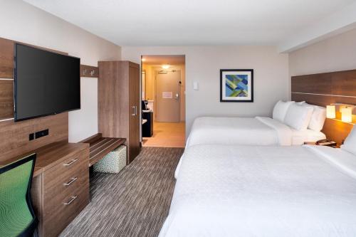a hotel room with two beds and a flat screen tv at Holiday Inn Express & Suites Halifax Airport by IHG in Enfield