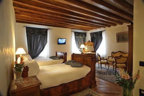 a bedroom with two beds in a room at Park Hotel Villa Carpenada in Belluno