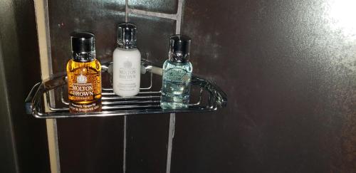 two bottles of whiskey on a shelf in a bathroom at Vu Guesthouse in Louisville