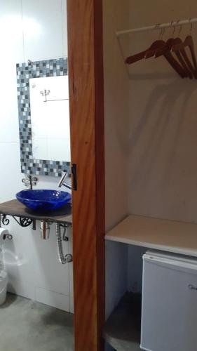 a bathroom with a blue sink and a mirror at Recanto Berço das Aguas in Piraquara