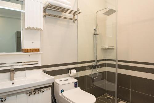 a bathroom with a shower and a toilet and a sink at Amora Hotel & Apartment in Vung Tau