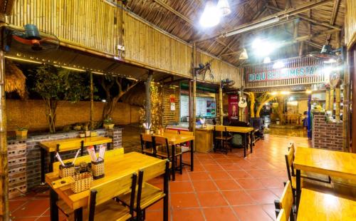 ein leeres Restaurant mit Holztischen und -stühlen in der Unterkunft Hoalu Backpacker Homestay in Ninh Bình