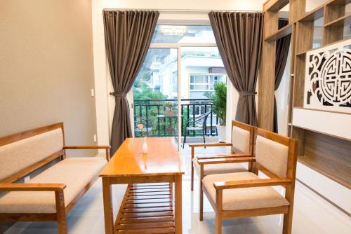 a dining room with a table and chairs and a window at Amora Hotel & Apartment in Vung Tau
