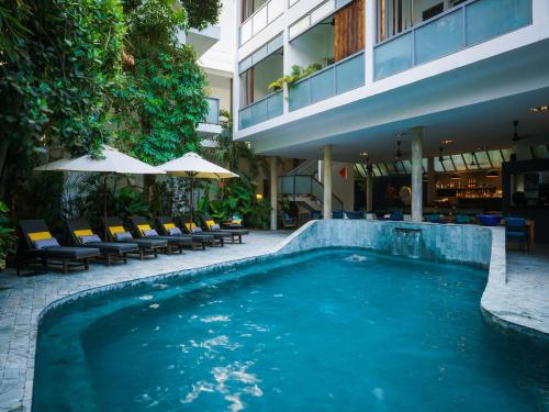 a swimming pool in front of a building at Rambutan Resort – Phnom Penh in Phnom Penh