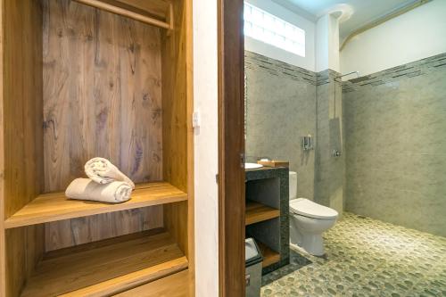 een badkamer met een douche, een toilet en een wastafel bij Esty House in Ubud