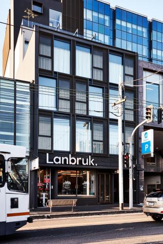 a bus parked in front of a large building at Urban Rest Lanbruk in Melbourne