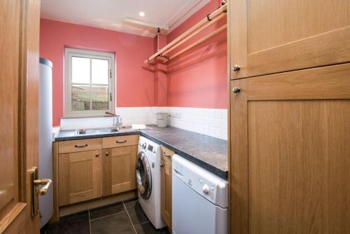 a kitchen with a washing machine and a sink at Time in Galashiels