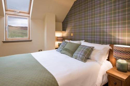 a bedroom with a white bed and a window at Time in Galashiels