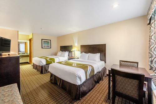 a hotel room with two beds and a flat screen tv at Quality Inn in Three Rivers