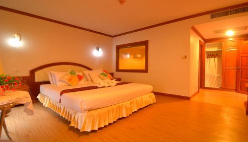 a bedroom with a large bed in a room at Chumphon Gardens Hotel in Chumphon