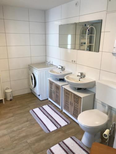 a bathroom with two sinks and a washing machine at König Ferienhaus in Königsbrück