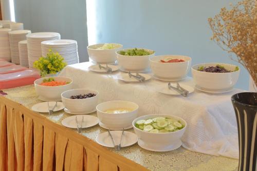 a table with bowls and spoons of food on it at Chumphon Gardens Hotel in Chumphon