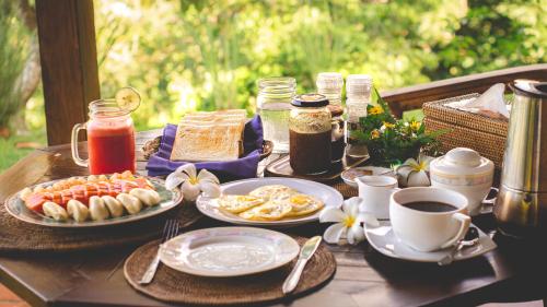 a table with plates of food and cups of coffee at The Studio in Senggigi 