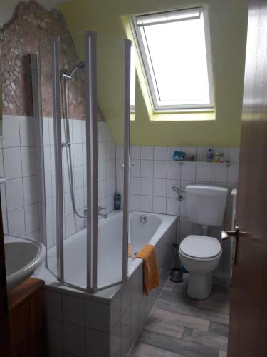 a bathroom with a tub and a toilet and a window at Urlaub am Auberg in Gerolstein