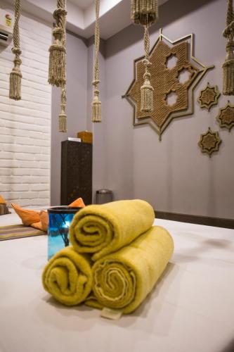 a pile of yellow towels sitting on top of a table at The Shalimar Hotel, Kemps Corner in Mumbai