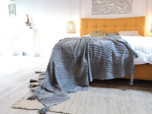 a bedroom with a bed with a blanket on it at LANDHOTEL 1707 by Landgasthof Zickler in Gleisweiler