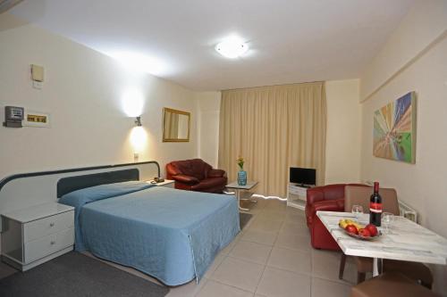 1 dormitorio con 1 cama y sala de estar en Sunquest Gardens Holiday Resort, en Limassol