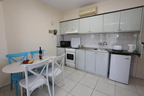 a kitchen with white cabinets and a table and chairs at Sunquest Gardens Holiday Resort in Limassol