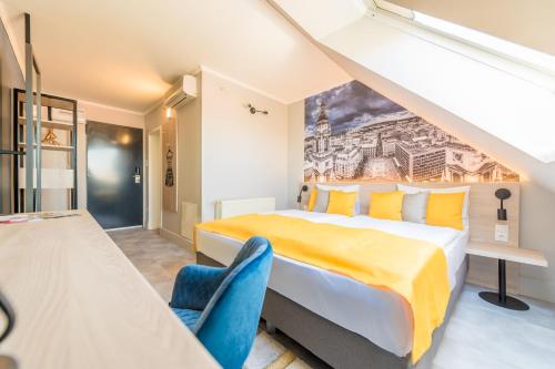 a bedroom with a large bed and blue chairs at Impulso Fashion Hotel in Budapest