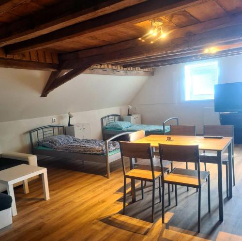 a room with two beds and a table and chairs at Penzion Ostrov u Stribra 13 in Kostelec