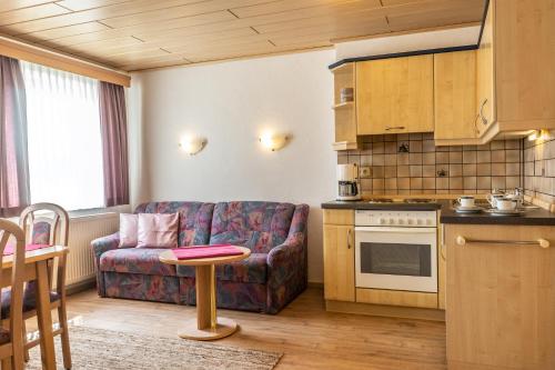 a kitchen and living room with a couch and a table at Gäste- und Appartementhaus Roswitha Huber in Würding