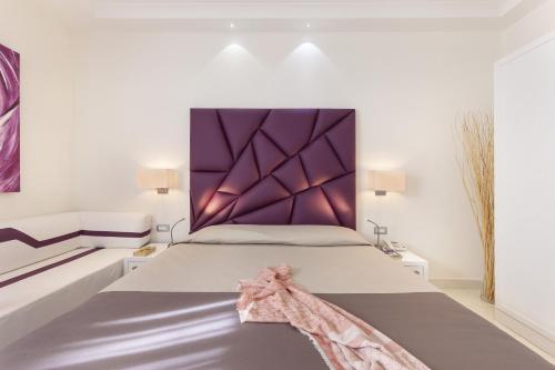 a bedroom with a large bed with a purple headboard at Palazzo Montefusco in Sorrento
