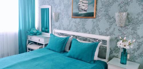 a bedroom with a blue bed and a mirror at Shalanda in Odesa