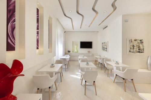 um restaurante com mesas brancas e cadeiras brancas em Palazzo Montefusco em Sorrento