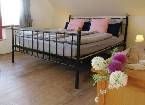 Schlafzimmer mit einem Bett mit rosa Kissen und einem Tisch in der Unterkunft Casita in Apensen