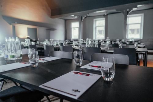 a room with tables and chairs with glasses on them at Hotel Riesengebirge in Neuhof an der Zenn