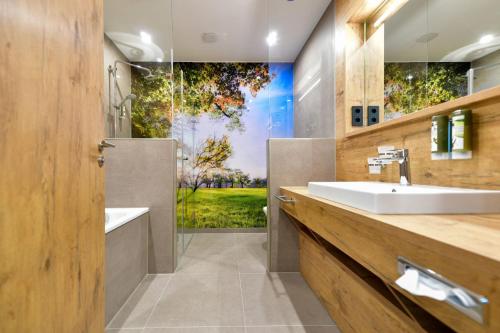 ein Bad mit einem Waschbecken und einer Dusche in der Unterkunft Best Western Plus Parkhotel & Spa Cottbus in Cottbus