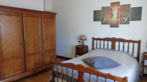 ein Schlafzimmer mit einem Holzbett und einer Holzkommode in der Unterkunft chambres d'hotes Lagarde in Lagarde