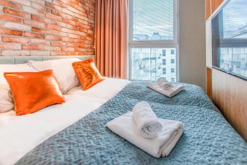 - une chambre avec 2 lits et des serviettes dans l'établissement Megi & Greg Apartments, à Gdańsk