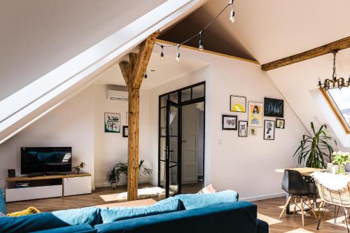 an attic living room with a blue couch at Apartament Dobre Miejsce 2 in Ustrzyki Dolne