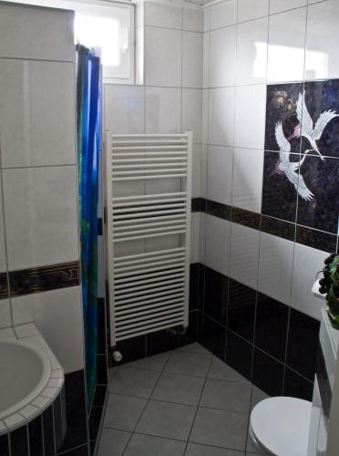 a bathroom with a shower and a toilet and a sink at B&B Marijke in De Koog
