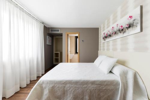 a bedroom with a large white bed in a room at Pension Residencial Victoria in Santa Cruz de Ribadulla