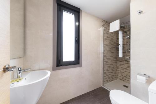 a bathroom with a sink and a toilet and a window at Pension Residencial Victoria in Santa Cruz de Ribadulla