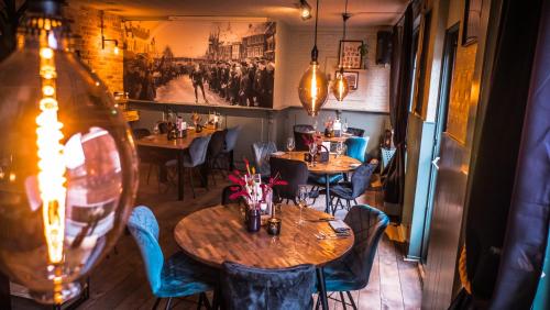 a restaurant with tables and chairs and a painting on the wall at Hotel Café Restaurant 't Raedhûs in Dokkum