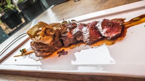 a piece of meat on a plate on a table at Hotel Café Restaurant 't Raedhûs in Dokkum