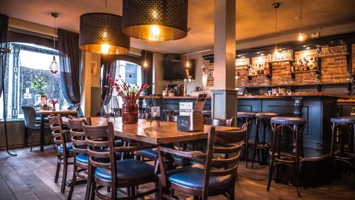 a restaurant with a wooden table and chairs at Hotel Café Restaurant 't Raedhûs in Dokkum