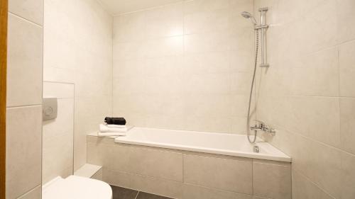 une salle de bain avec une baignoire, des toilettes et une douche dans l'établissement Les 4 Elements - Apt D102 - BO Immobilier, à Châtel